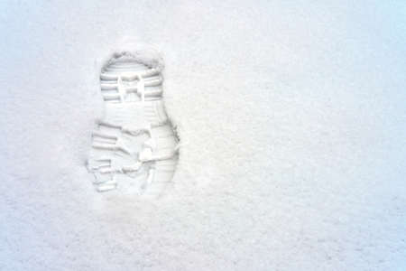 Footprints in the snow, under a thin layer of which is visible white coating, copy spaceの写真素材