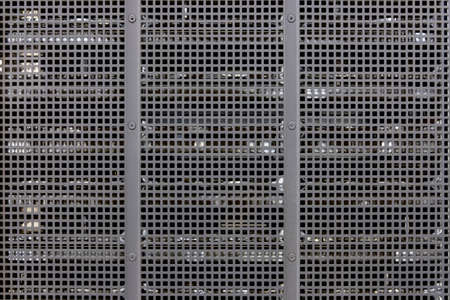 Metal grill background with blurred background of technological equipment, copy spaceの写真素材