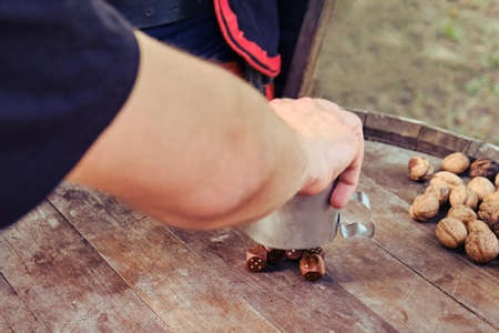 Man hand throw dice on a barrel. People in ancient costumes pour out dice from an iron mug on a table from a wooden barrelの写真素材