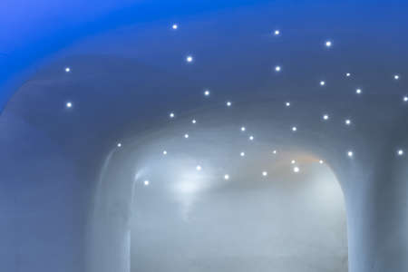Ice cave with glowing lamps on the snow ceilingの写真素材