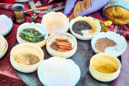 Spices in half-empty bowls for sale on the market. Trade of spices at the Bazaar. A Muslim spice merchant's shop.の写真素材