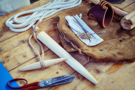 Retro tools of the sailors of the navy. Rope, needles, scissors, wooden wedges and hammer for ship...