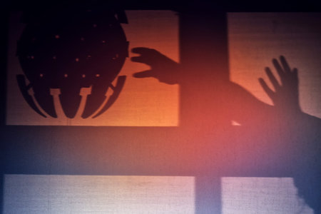 The silhouette of a UFO and human hands, the concept of contact with an extraterrestrial...