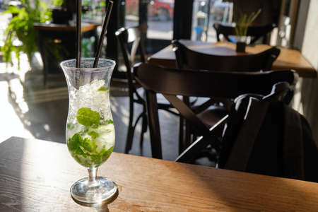 Mojito in a glass with a tube on the cafe tableの写真素材
