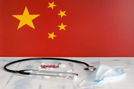 Chinese flag on the background of pills and a medical mask on the table. Chinese flag and medical suppliesの写真素材