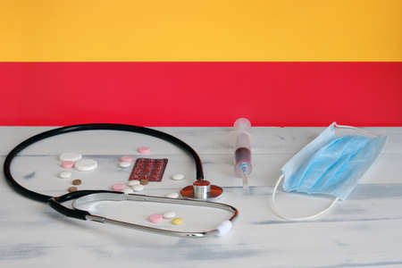 Spanish flag on the background of tablets, stethoscope and medical mask on the table. The flag of Spain and medical suppliesの写真素材