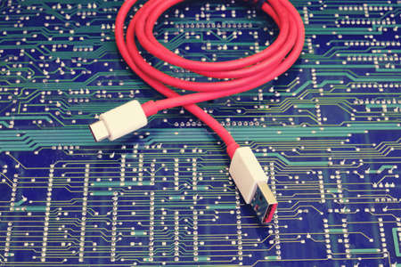 Red usb wire against electronic circuit boardの写真素材