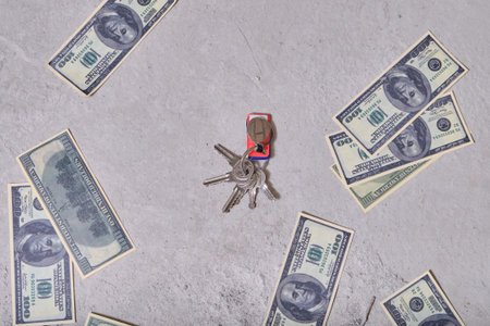 The money is on the dirty floor and the keys to the house. Dollars close-up lying on the ground....