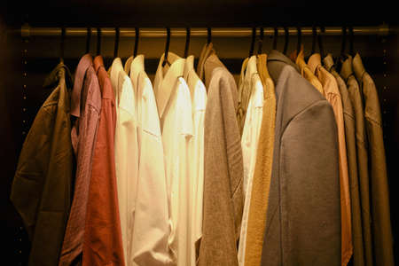 Clothes hang on a hanger in the closetの写真素材