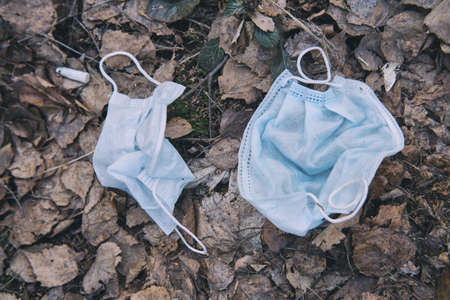Two medical protective mask thrown into the trashの写真素材