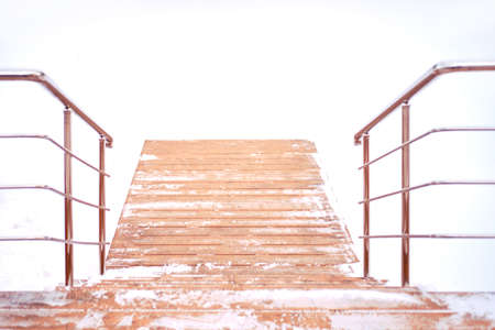 Steps to the platform at the snow-covered pondの写真素材