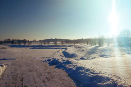 Winter landscape with frozen pond and sunの写真素材
