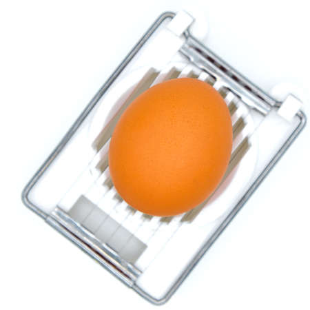 Egg in the device for cutting. Device for cutting food. White background, isolate.の写真素材