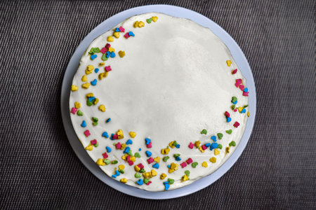 Cake candy sprinkles on a gray background. The view from the top of the cake standing on the table....