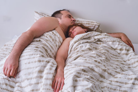 Couple husband and wife sleeping on the bed, real lifestyle. Non-staged family photo