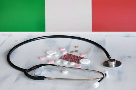 Italian flag on a background of pills and a stethoscope on the table. Italy flag and medical suppliesの写真素材