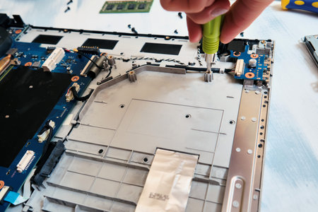 Disassembling the laptop on the table with a screwdriver