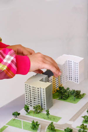 Children's hands build a toy house, close-up