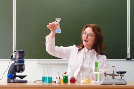 Surprised woman chemistry teacher in class at school. Conducting scientific research in the student laboratoryの写真素材