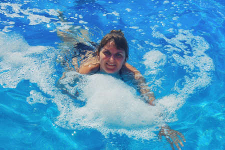 Young woman swimming in foam at pool party, close upの写真素材