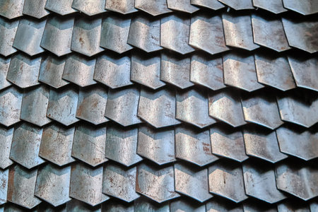 Texture of ancient Roman armor plates, Lorica. Background of rusty chain mail armor from connected plates, close-up. Armor worn from the metallic flakes.の写真素材