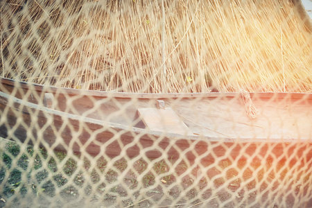 Retro boat behind the net in a fishing village. Large net for catching fish.
