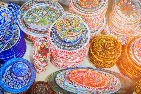 Colorful dishes and bowls with Arabic ornaments in the bazaar shop of Tunisia.の写真素材