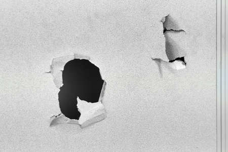 Wall of a building punched through by a hand fistの写真素材