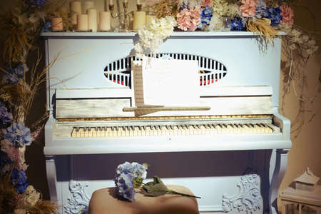 Vintage blue piano decorated with flowers and candlesの写真素材