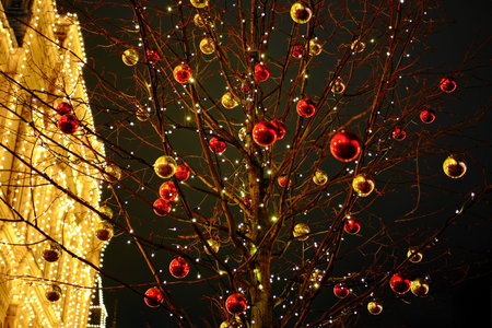 Yellow and red Christmas balls on a tree as an element of decorating city streets for the New Year