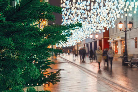 Evening city street with hurrying people, new year's eve and christmasの写真素材