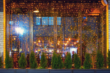 Street window cafe are decorated with garlands on the eve of new year and Christmasの写真素材