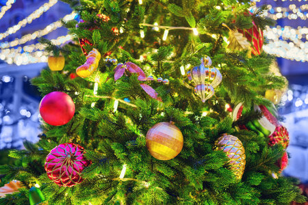 Christmas tree decorated with balls, garlands and bauble on the street during the New Years...