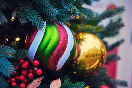 Striped Christmas ball and red mistletoe berry, close-upの写真素材
