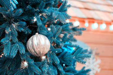 Christmas tree with icicles and balls as a decoration of the yard of a wooden house, new yearの写真素材