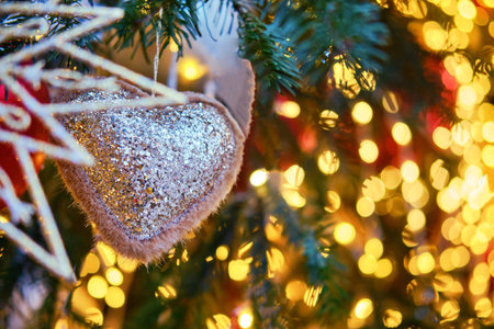 Christmas tree decorated with a toy glitter soft heart. Preparation of ornaments for the celebration...