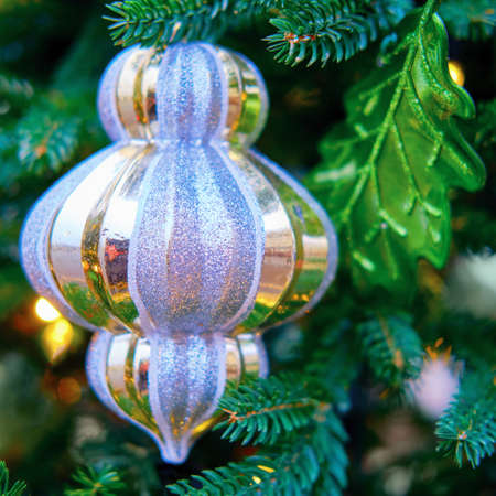 Elongated striped Christmas toy and oak leaf, close-upの写真素材