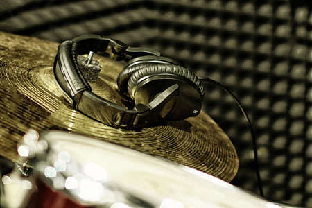 Gold plates and headphones from the drum set in the recording Studio. Professional drummers play recordingの写真素材