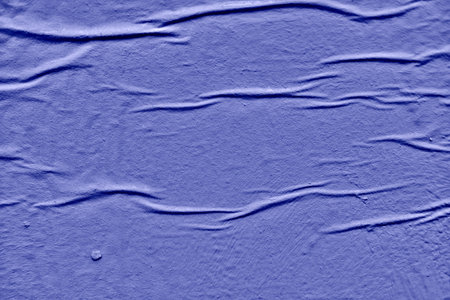 Wall background with bloated paint and swollen blue wallpaper