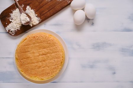 Flour and eggs for cooking sponge cake on white wooden background, copy spaceの写真素材