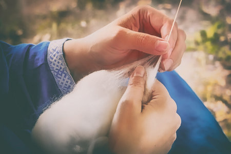 Creating yarn threads, close-up. Distaff in nature, rustic style