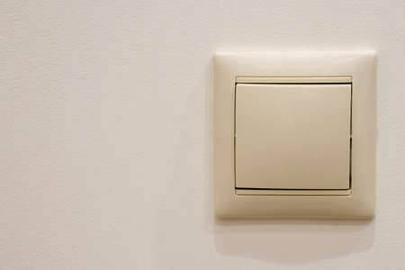 Single switch on a beige painted wall, copy spaceの写真素材