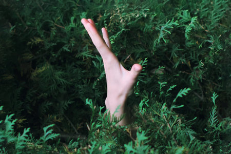 Tree holds the man. Hand is visible from the green spaces. Bushes hold the man, the concept of...