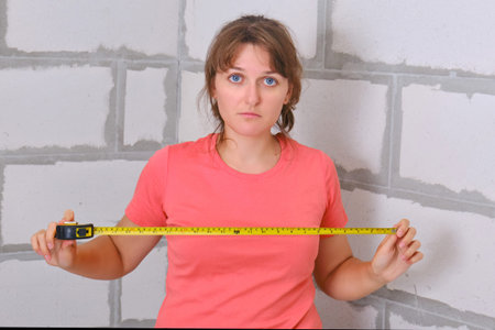Carrying out independent uncertain measurements in the repair of a new apartment. The young woman...