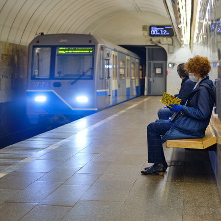 Woman in medical masks in the Russia metro. Quarantine in Moscow city. Underground urban transport....