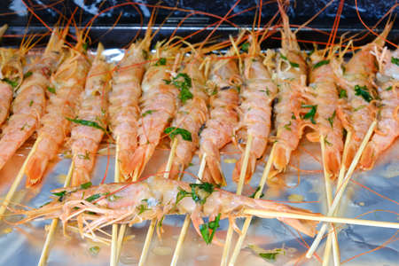 Cooking langoustines on skewers in the ovenの写真素材