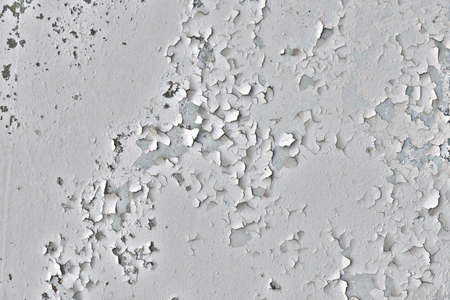 Background of plaster plaster from the wall. The texture of peeling white plaster on the wall. Cracked painting of an ancient surface.の写真素材