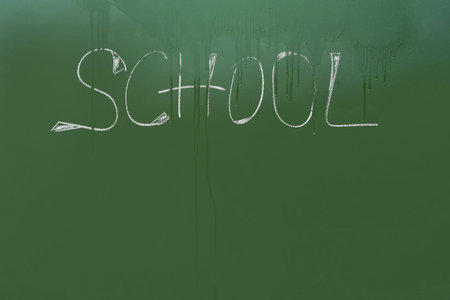The inscription School on the blackboard is washed off with drops of water, the concept of...