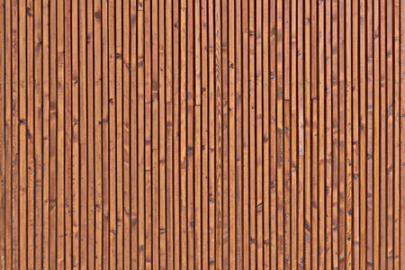 Background of the boards facing the wall. The texture of the wooden surface of the boards. Smooth dark brown planks with knots.の写真素材