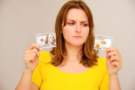 Torn dollars in the hands of a woman - a symbol of problems in the financial market and currency...